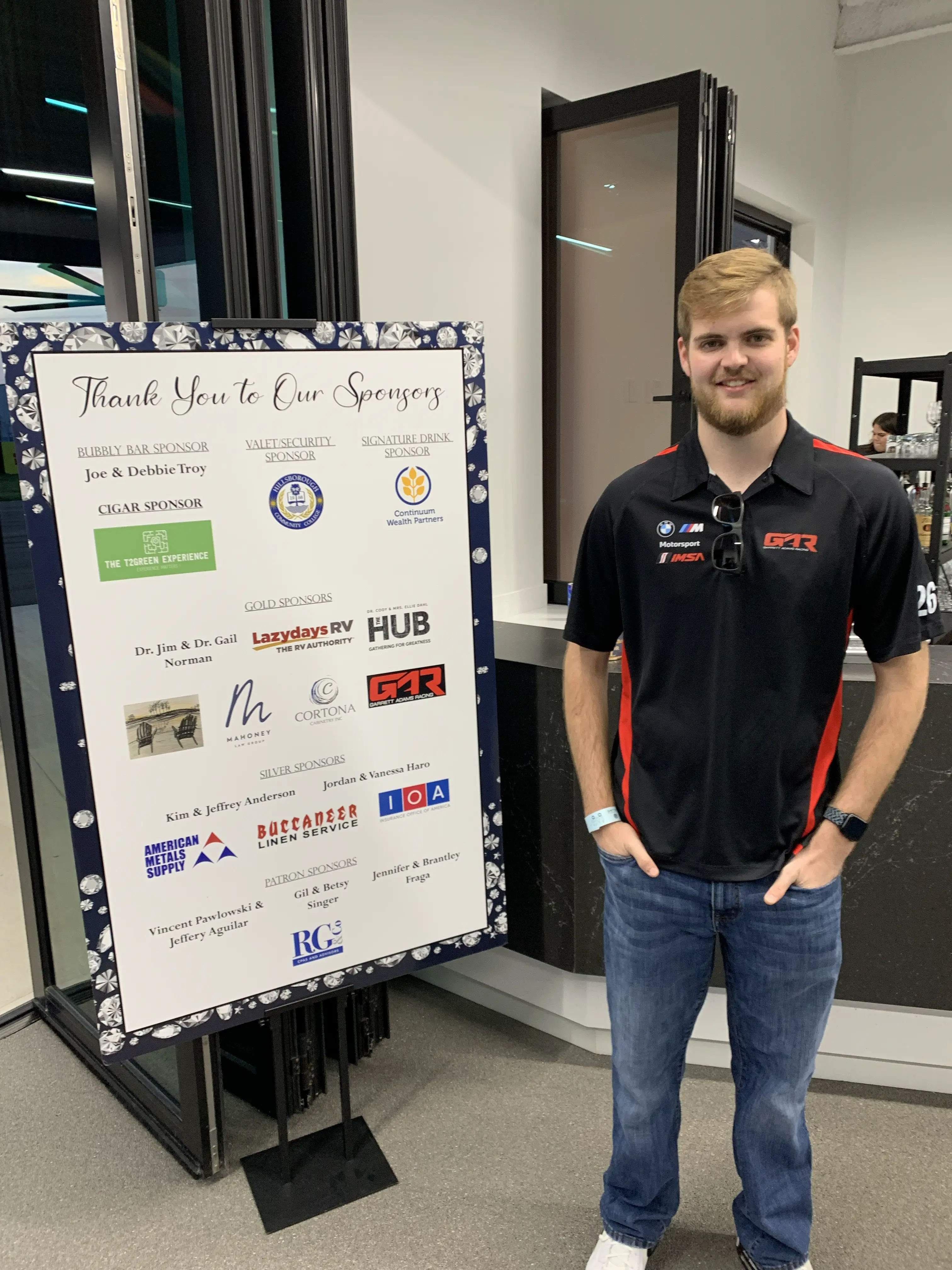 Portrait: Garrett (The GMan) smiling next to a high-end car buffer in a clean, professional detailing garage.